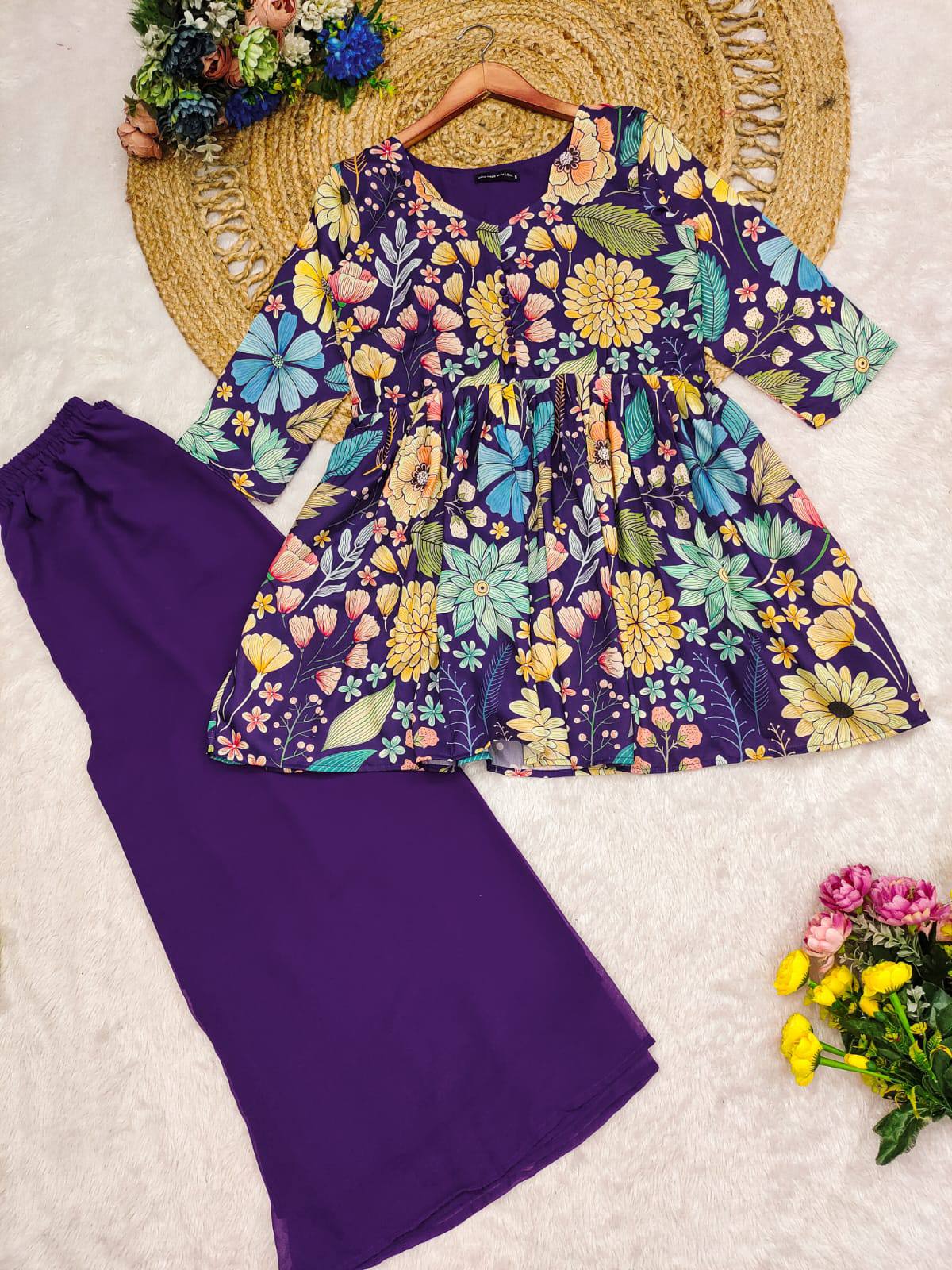 Floral top and purple pants on a textured surface with flowers around